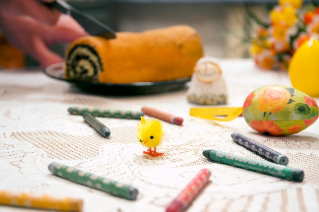 Vibrant Easter-themed table setting with festive cake, crayons, and decorations.